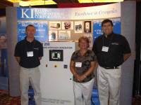 Paul Rowe, Wessington Cryogenics (left), Donna Jung, and Al Guerra, Kelvin International Corporation (right) stand in front of the Kelvin International booth.